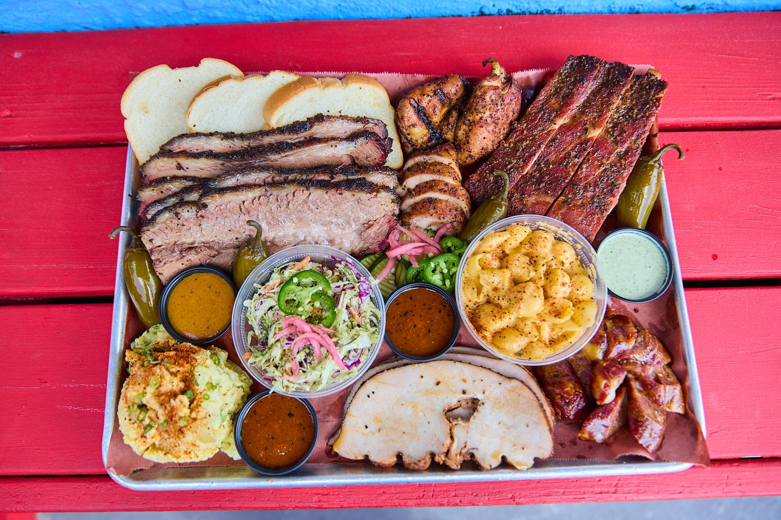 A spread of Two Goose smoked meats: brisket, turkey, pork belly, chicken and sausage